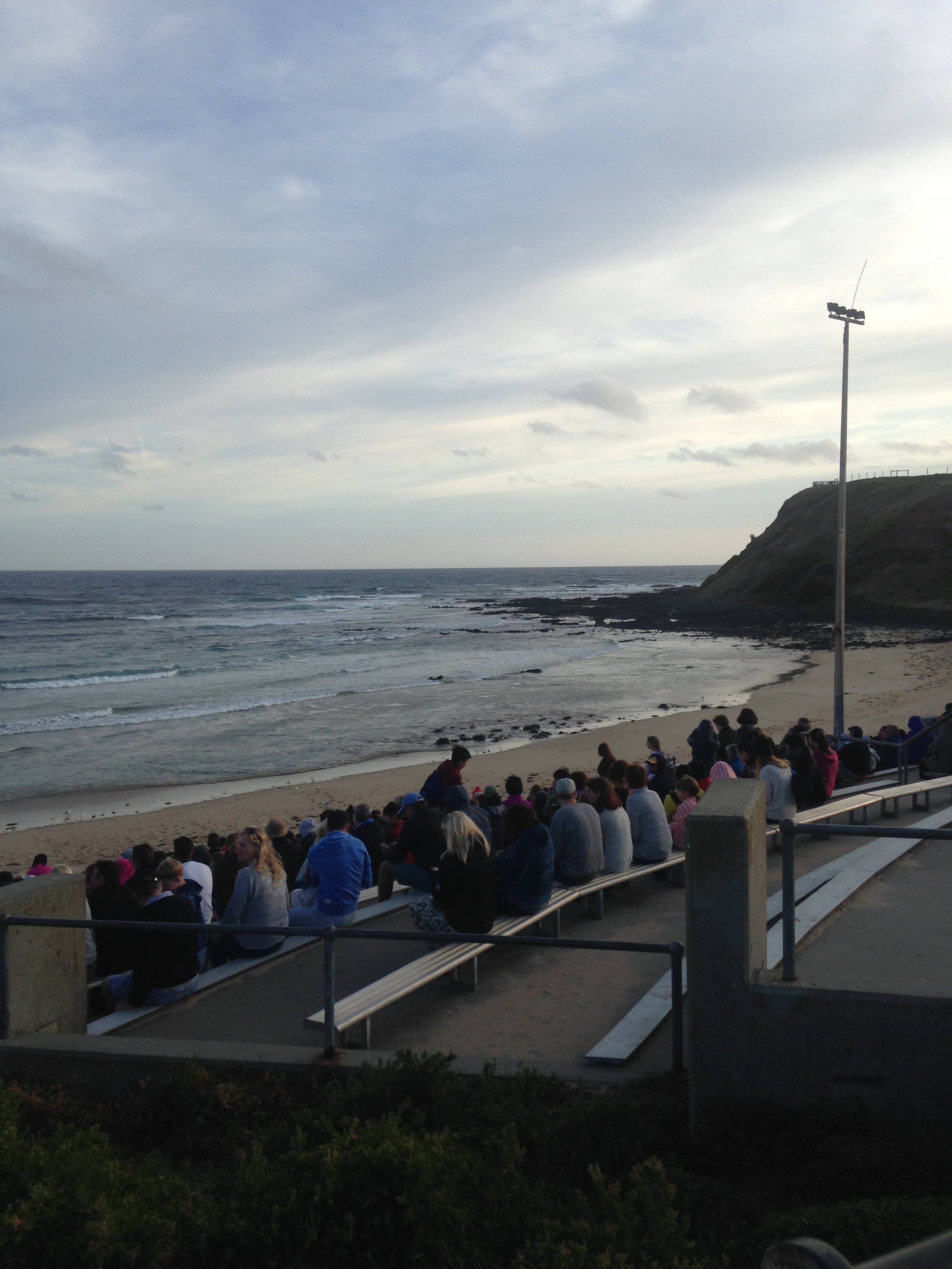 Tourists sit on a bench on a beachfront in Australia