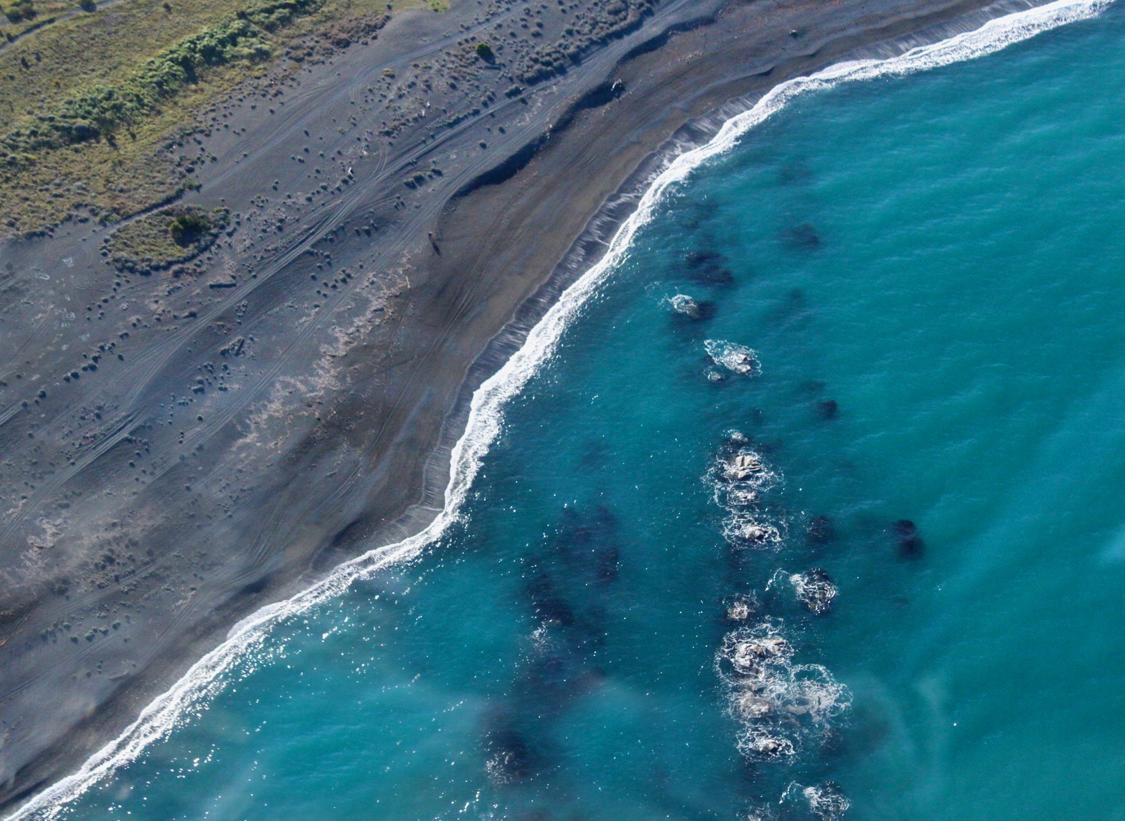 clear blue waters lapping at grey beach