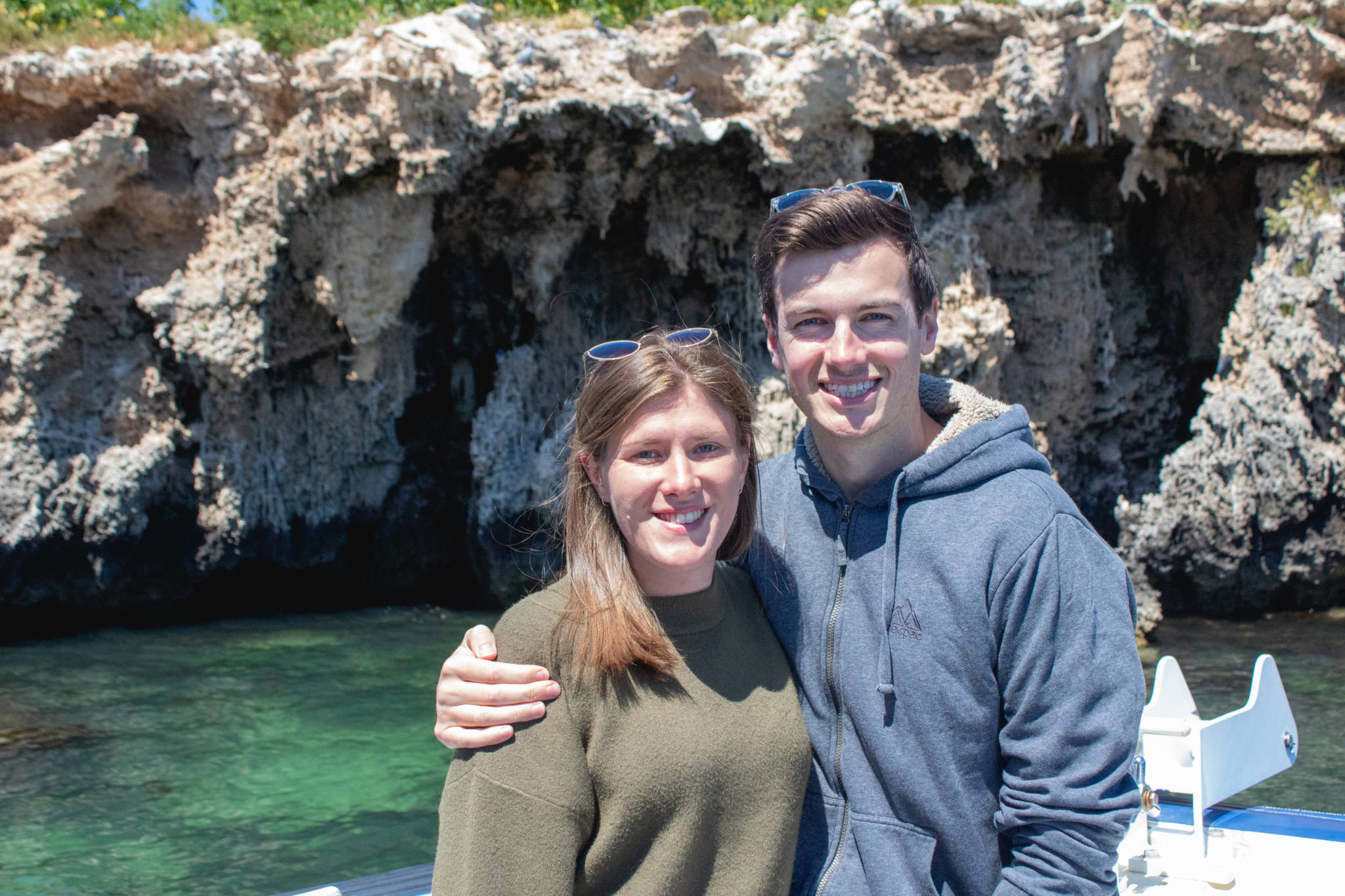 couple stand in front of aladdin's cave in shoalwater marine reserve