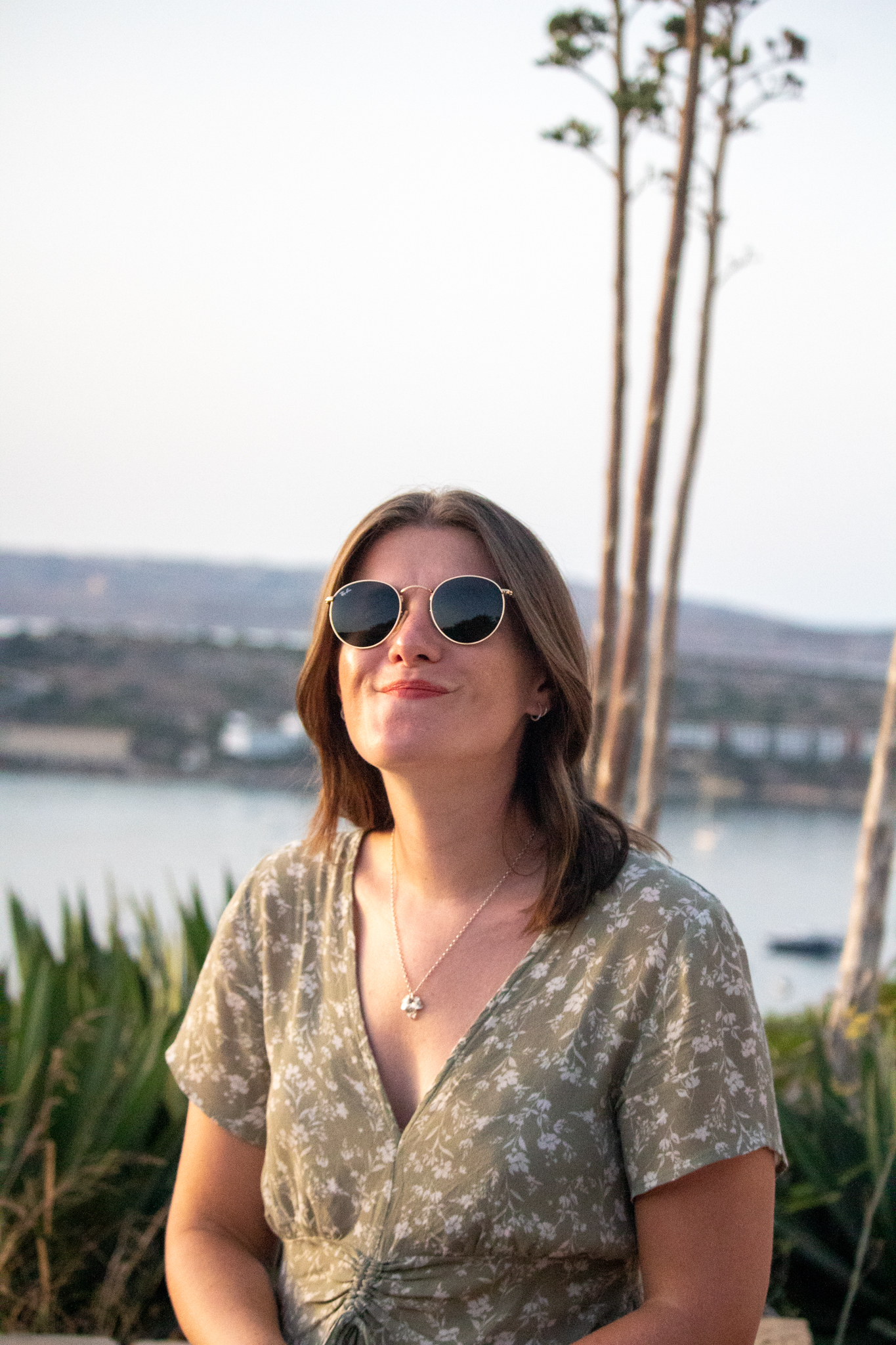 a woman smiles at the camera at sunset